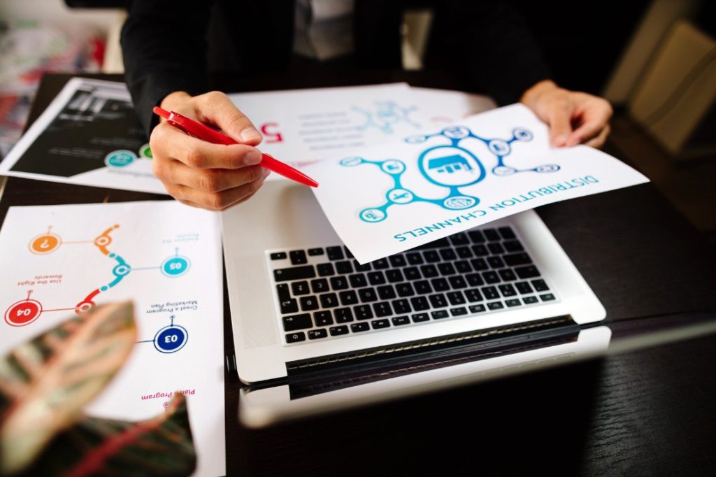 Marketing-Manager-Schreibtisch mit Plänen und Strategien der Vertriebskanäle für neue Produkte