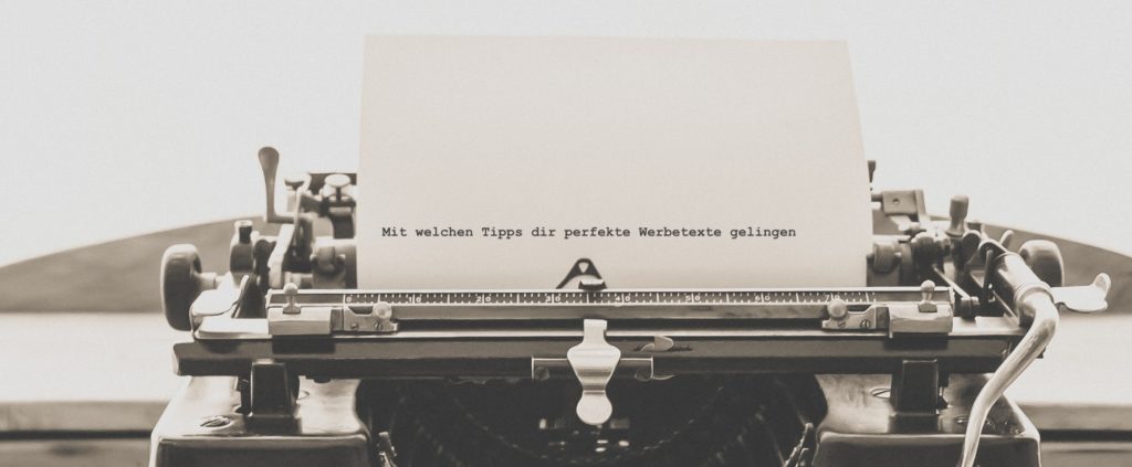 Schreibmaschine die ein Blatt Papier mit geschriebenem Text enthält