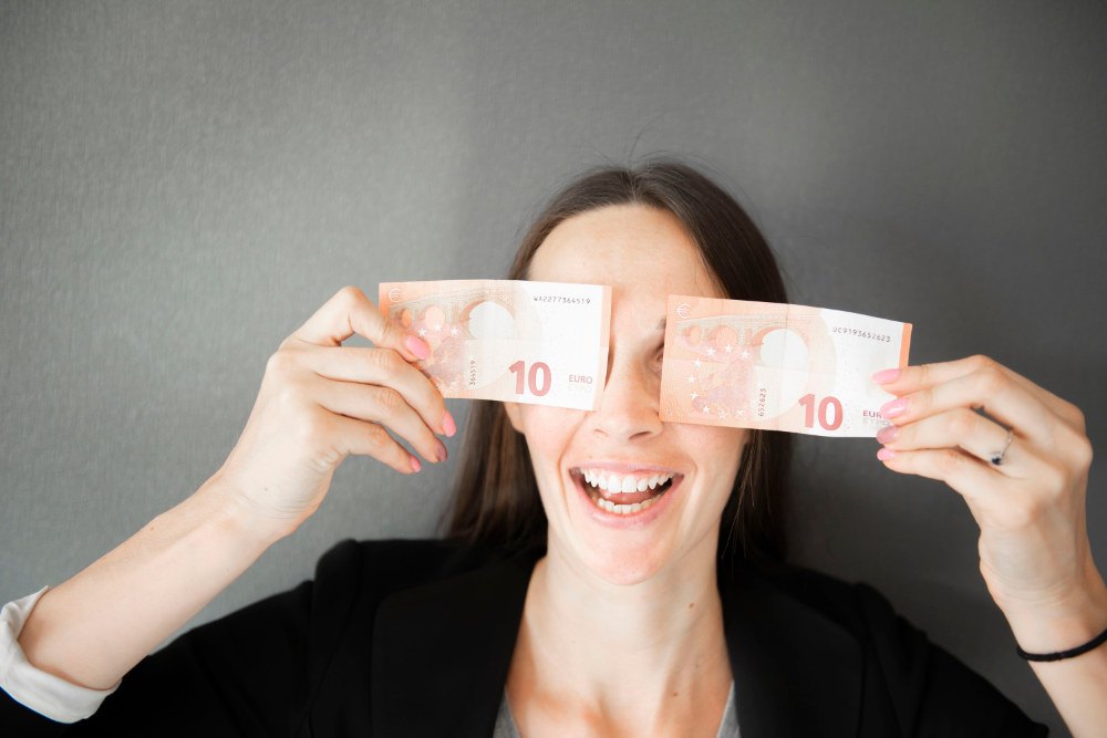 Glückliche Frau mit zwei 10 Euro Scheinen in der Hand