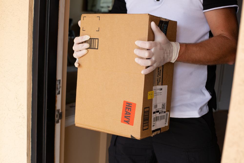 Mann hält Amazon Prime Paket an der Wohungstüre