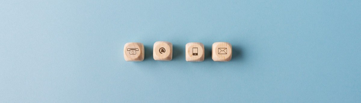Beitragsbild: Kontakt und Kommunikation Icons, aus Holzwürfeln, mit blauem Hintergrund