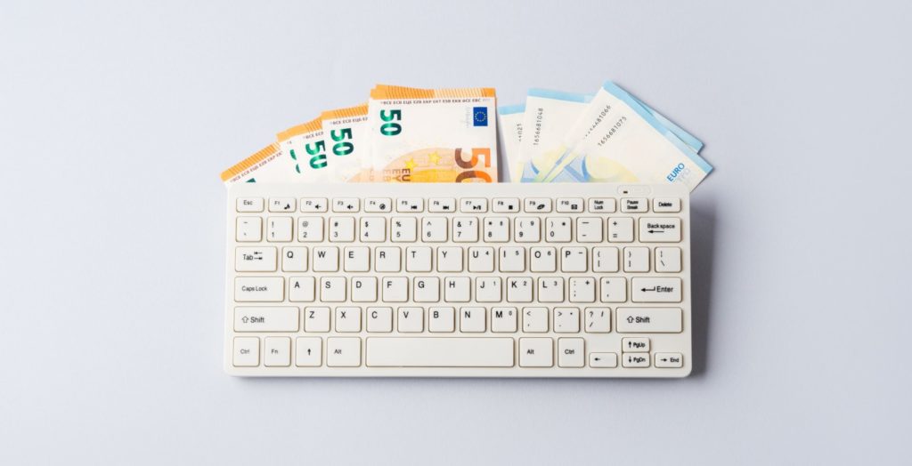 digitale Produkte verkaufen, Euro Banknoten unter einer Tastatur
