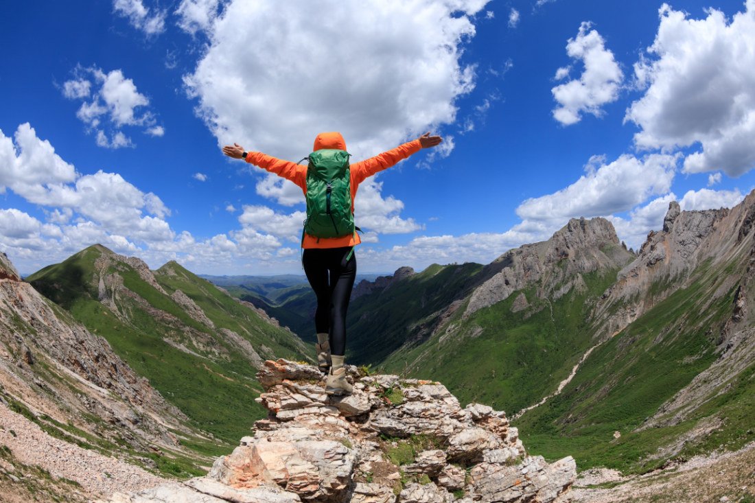 Erfolgreiche Frau, Rucksack-Reisende, wandernd in den Alpen an einer Bergspitze