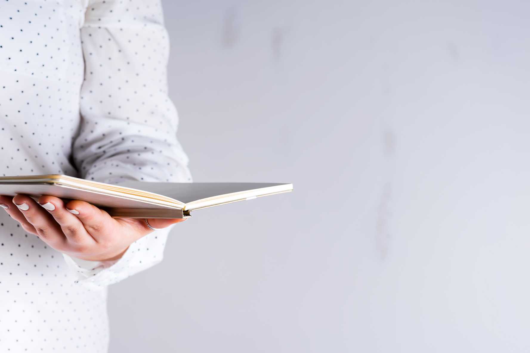 Ein Buch in der Hand haltend